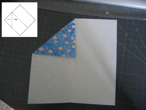 Con el revés del papel hacia arriba, doblar una esquina sobre el pliegue central marcado en el paso anterior